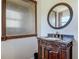 Bathroom vanity with round mirror and framed textured glass panel above at 156 S State Road 415, New Smyrna Beach, FL 32168