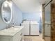 Bright bathroom features marble vanity, new fixtures, and a walk-in shower with glass door at 156 S State Road 415, New Smyrna Beach, FL 32168