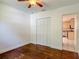 Bedroom featuring hardwood floors, closet with sliding doors, and a view of the kitchen at 156 S State Road 415, New Smyrna Beach, FL 32168