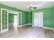 This large bedroom has green walls, ample closet space, and access to a backyard patio at 156 S State Road 415, New Smyrna Beach, FL 32168