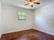 Bedroom with hardwood floors, a ceiling fan, and a window with natural light at 156 S State Road 415, New Smyrna Beach, FL 32168