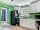 The updated kitchen has sleek white cabinets, stainless steel appliances, and a convenient sink at 156 S State Road 415, New Smyrna Beach, FL 32168