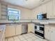 Bright kitchen features stainless steel appliances and white cabinets offering ample storage at 156 S State Road 415, New Smyrna Beach, FL 32168