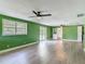 Spacious living room with lots of light, ceiling fan, and wood-look flooring at 156 S State Road 415, New Smyrna Beach, FL 32168