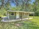 Guest house with a covered porch and a well-maintained lawn at 156 S State Road 415, New Smyrna Beach, FL 32168