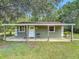 Exterior view of the building with a covered porch and green siding at 156 S State Road 415, New Smyrna Beach, FL 32168