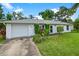 Charming white brick home with a well-manicured lawn and garden, featuring an attached garage at 1903 Willow Oak Dr, Edgewater, FL 32141