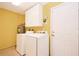 Laundry room featuring a washer, dryer, water heater, and cabinets at 1903 Willow Oak Dr, Edgewater, FL 32141