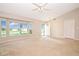Open-concept living room with carpeted floor, large windows, and a ceiling fan at 1903 Willow Oak Dr, Edgewater, FL 32141
