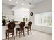 Eat-in kitchen dining area with bar seating, white cabinetry, chandelier, and natural light from the window at 2 Oceans West Blvd # 206, Daytona Beach Shores, FL 32118