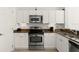 Kitchen featuring stainless steel appliances, white cabinets, and granite countertops at 2 Oceans West Blvd # 206, Daytona Beach Shores, FL 32118