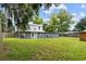 Large backyard featuring a gray and white two-story house and wooded perimeter at 2005 Sunny Ln, New Smyrna Beach, FL 32168