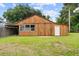 Wood barn with sliding door and attached carport perfect for extra storage at 2005 Sunny Ln, New Smyrna Beach, FL 32168