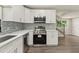 Modern kitchen featuring stainless steel appliances, white cabinets, and gray backsplash at 2005 Sunny Ln, New Smyrna Beach, FL 32168