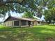 View of the backyard featuring mature trees and a screened lanai at 2029 Willow Oak Dr, Edgewater, FL 32141