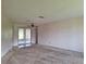 Spacious living room with carpet flooring, ceiling fan, and access to the backyard at 2029 Willow Oak Dr, Edgewater, FL 32141