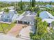Aerial view of the home, highlighting the brick driveway, roof, surrounding neighborhood, and mature landscaping with palm trees at 206 Kirkland Rd, New Smyrna Beach, FL 32169