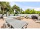 Large backyard with a dining table and chairs, a spa, a fire pit, and an outdoor kitchen at 206 Kirkland Rd, New Smyrna Beach, FL 32169