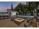 Inviting backyard patio with a spa, fire pit, comfortable seating, and outdoor dining area at 206 Kirkland Rd, New Smyrna Beach, FL 32169