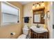 Bathroom with wood mirror and cabinet, neutral walls, and tub shower with white curtain at 206 Kirkland Rd, New Smyrna Beach, FL 32169