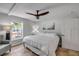 Bedroom featuring queen bed with white comforter, ceiling fan, and view of exterior patio at 206 Kirkland Rd, New Smyrna Beach, FL 32169