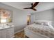 Bedroom featuring queen bed with decorative pillows, ceiling fan, and sea life painting at 206 Kirkland Rd, New Smyrna Beach, FL 32169