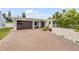 Home featuring a brick driveway leading to a one-car garage with a modern dark wood door at 206 Kirkland Rd, New Smyrna Beach, FL 32169