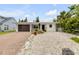 Charming single-story home featuring a modern garage door, brick driveway, and low maintenance landscaping at 206 Kirkland Rd, New Smyrna Beach, FL 32169