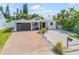 Charming single-story home featuring a modern garage door, brick driveway, and low maintenance landscaping at 206 Kirkland Rd, New Smyrna Beach, FL 32169