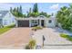 Charming single-story home featuring a brick driveway, modern garage door, and beautifully landscaped front yard with mature palms at 206 Kirkland Rd, New Smyrna Beach, FL 32169