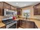 Close-up of kitchen with stainless steel appliances, granite countertops, and dark wood cabinets at 206 Kirkland Rd, New Smyrna Beach, FL 32169