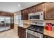 Kitchen with stainless steel appliances, granite countertops, dark wood cabinetry, and tile floors at 206 Kirkland Rd, New Smyrna Beach, FL 32169