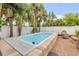 Inviting pool area surrounded by lush tropical landscaping and a white privacy fence at 206 Kirkland Rd, New Smyrna Beach, FL 32169