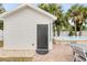 Close up of a pool house adjacent to a pool and gray outdoor dining set at 206 Kirkland Rd, New Smyrna Beach, FL 32169