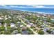 Stunning aerial view of a charming home near the ocean with lush landscaping in a desirable coastal neighborhood at 22 Sand Dune Dr, New Smyrna Beach, FL 32169