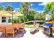 Paver patio in a shady backyard with a table, chairs, grill, and mature landscaping at 22 Sand Dune Dr, New Smyrna Beach, FL 32169