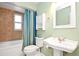 Cozy bathroom featuring a tub-shower combo, pedestal sink, and a soothing color palette, perfect for unwinding at 22 Sand Dune Dr, New Smyrna Beach, FL 32169