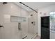 Modern bathroom featuring a glass-enclosed shower, textured walls, and black hardware at 22 Sand Dune Dr, New Smyrna Beach, FL 32169