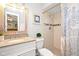 Bright bathroom with a shower, white vanity with a light granite countertop, and a white toilet at 22 Sand Dune Dr, New Smyrna Beach, FL 32169