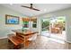 Bright dining area with a rustic wooden table, bench seating, and sliding glass doors to a serene outdoor space at 22 Sand Dune Dr, New Smyrna Beach, FL 32169