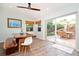 Bright dining area with a rustic wooden table, bench seating, and sliding glass doors to a serene outdoor space at 22 Sand Dune Dr, New Smyrna Beach, FL 32169