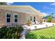 Charming stone home features a patio with seating, complemented by lush greenery and a well-manicured lawn at 22 Sand Dune Dr, New Smyrna Beach, FL 32169