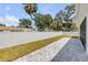 Backyard featuring a paved patio, grassy area, and a white fence, enhancing privacy at 2324 Orange Tree Dr, Edgewater, FL 32141