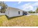 Backyard featuring a paved patio, grassy area, and exterior view of the home with a white fence at 2324 Orange Tree Dr, Edgewater, FL 32141
