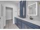 Bright bathroom featuring double vanity with blue cabinets, white countertop, and modern, lighted mirrors at 2324 Orange Tree Dr, Edgewater, FL 32141