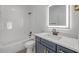 Bathroom boasts tub, white vanity with blue cabinets, quartz counter, and LED mirror at 2324 Orange Tree Dr, Edgewater, FL 32141