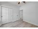 Bright bedroom with gray wood-look floors, ceiling fan, and sliding-door closet at 2324 Orange Tree Dr, Edgewater, FL 32141