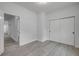 Bright bedroom features gray wood-look floors, a sliding-door closet, and a doorway to another room at 2324 Orange Tree Dr, Edgewater, FL 32141