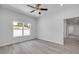 Bedroom featuring modern ceiling fan, large window, and access to bathroom and hallway at 2324 Orange Tree Dr, Edgewater, FL 32141