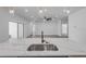 Bright, modern kitchen island with sink, and open view to living space with fan at 2324 Orange Tree Dr, Edgewater, FL 32141